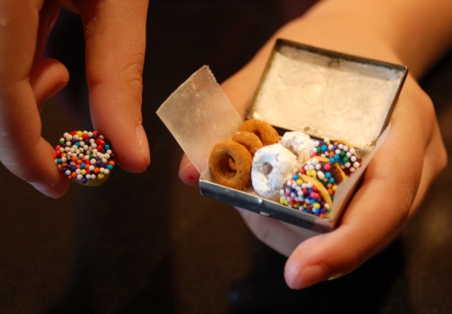 The box of donuts is really a pill box....Emma's holding her favorite, a cheerio dipped in chocolate, then sprinkles. The others are cheerio dipped in confectioners' sugar and cheerios rolled in cinnamon sugar.
